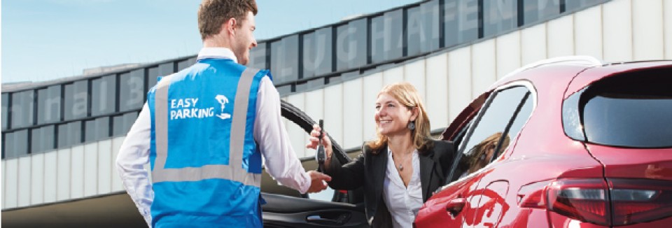 Frau übergibt einem Easy-Parking-Mitarbeiter am Flughafen Wien die Autoschlüssel für den Parkservice.
