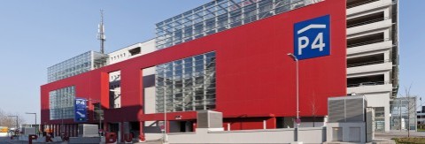 Außenansicht des Parkhauses P4 am Flughafen Wien mit moderner roter Fassade.