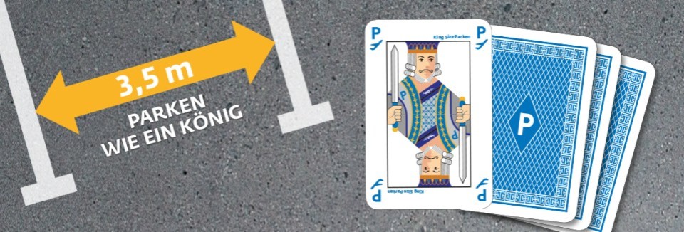 Spielkarte mit König und Text „3,5 m – Parken wie ein König“ auf Asphalt mit Parkplatzmarkierung.