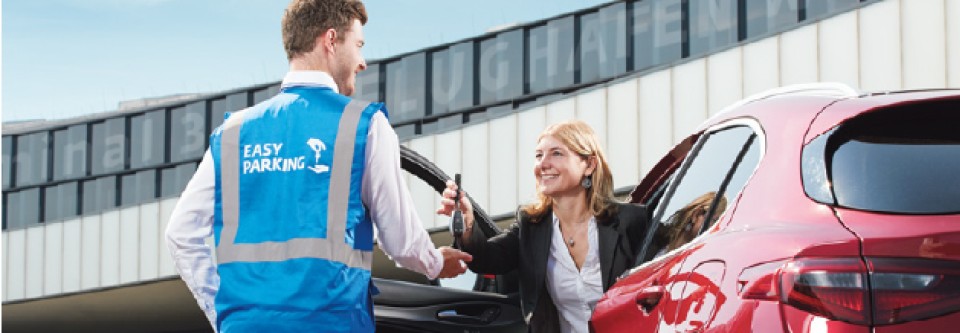 Frau übergibt einem Easy-Parking-Mitarbeiter am Flughafen Wien die Autoschlüssel für den Parkservice.