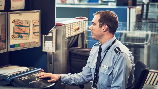 Mitarbeiter bei der Kontrolle des gescannten Gepäcks