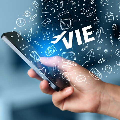 Hand hält ein Smartphone aus dem Symbole die Apps andeuten sollen und das VIE Logo erscheinen.